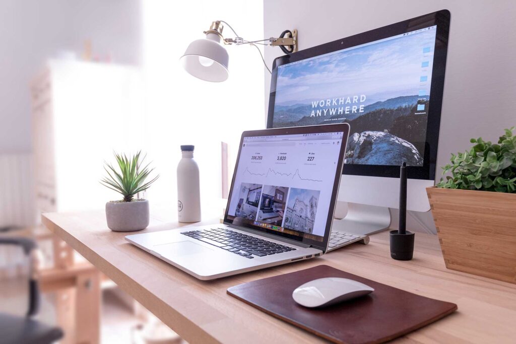 A laptop and mouse on top of a desk.